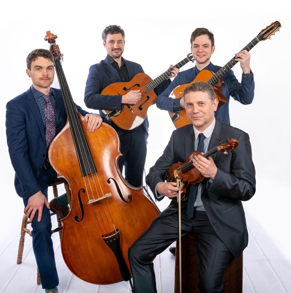 Four musicians with double bass, guitars and violin standing in a group